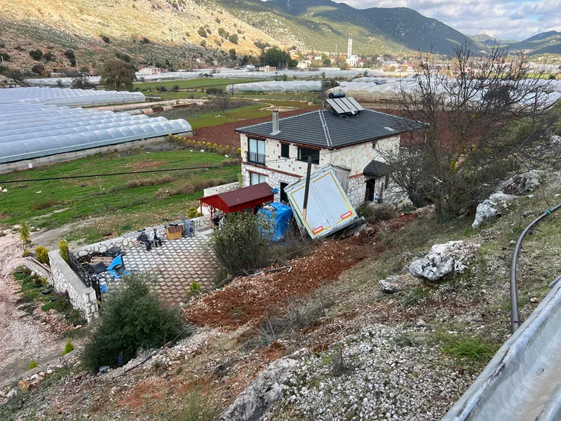 Antalya'da şarampole devrilen tırın bir eve çarparak durabildiği kazada sürücü yaralandı