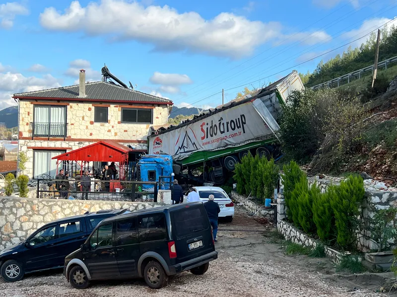 Antalya'da şarampole devrilen tırın bir eve çarparak durabildiği kazada sürücü yaralandı